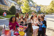 © Monkey Business - Neighbours helping themselves to food at a block party