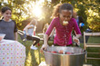 © Monkey Business - Pre-teen girl, apple in mouth, apple bobbing at garden party