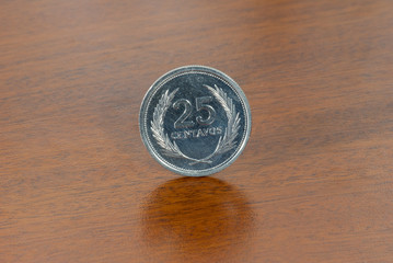 El Salvador coin 25 cents 1992, currency over wood texture.