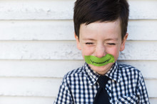Little Boy With A Monster Smile Taped On His Face
