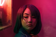 © Jesse Morrow/Stocksy - Portrait of young asian female woman in pink room with neon lights