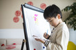 © Bo Bo/Stocksy - little asian boy drawing rooster indoor