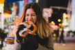 © Lauren Naefe/Stocksy - Young woman eating pretzel in New York City (NYC)