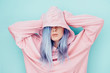 © Nemanja Glumac/Stocksy - Young woman with blue dyed hair in pink hoodie