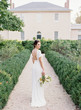 © Vicki Grafton Photography/Stocksy - Beautiful young bride standing in garden holding a flower bouquet