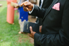 Close Up Of An African Man's Hands Holding A Bible.