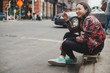 © Lauren Naefe/Stocksy - Skateboarder on curb in the city