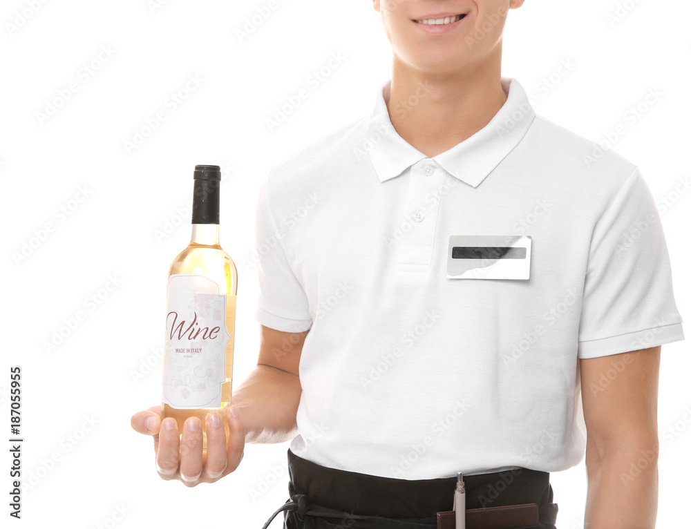 Handsome young waiter with bottle of wine on white background