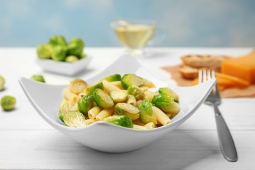 Canvas Print - Plate of pasta with Brussels sprouts on table