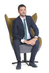 Handsome businessman sitting in comfortable armchair on white background