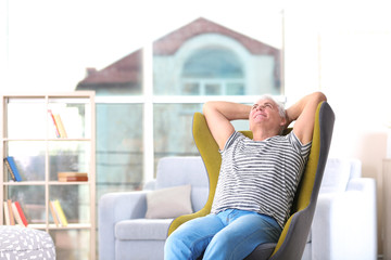 Poster - Handsome mature man sitting in comfortable armchair indoors