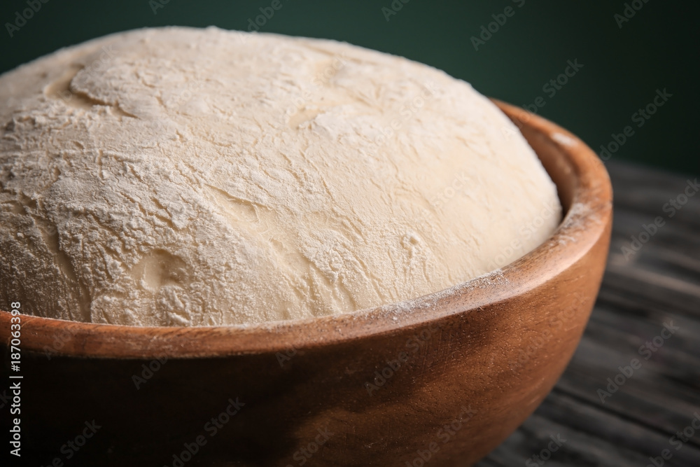 Bowl with fresh raw dough on table, closeup