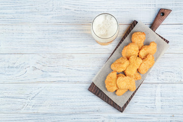 Sticker - Tasty chicken nuggets and glass of beer on table