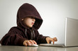 © triocean - Young hacker in hoodie in front of laptop
