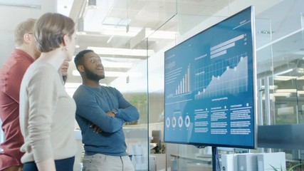 Poster - Diverse Team of Young Professionals in Conference Room Have Discussion about Statistics and Graphs Shown on a Presentation TV.  Shot on RED EPIC-W 8K Helium Cinema Camera.