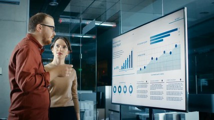 Poster - Male and Female Business Coworkers in Conference Room Have Discussion about Statistics and Graphs Shown on a Presentation TV.  Shot on RED EPIC-W 8K Helium Cinema Camera.