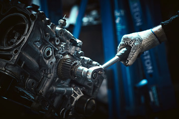 Closeup repair of an opposing engine by an auto mechanic.