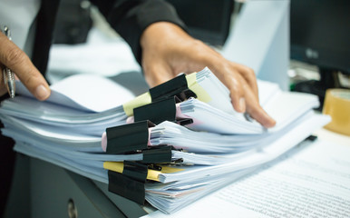 Canvas Print - Businesswoman hands working on Stacks of documents files for finance in office. Business report papers or Piles of unfinished document achieves with black clip paper. Concept of Business Annual Report