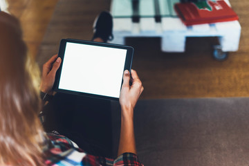 Wall Mural - Hipster girl using tablet technology in home atmosphere, girl person holding computer with blank screen on background bokeh, female hands texting on relax holiday, mockup templates