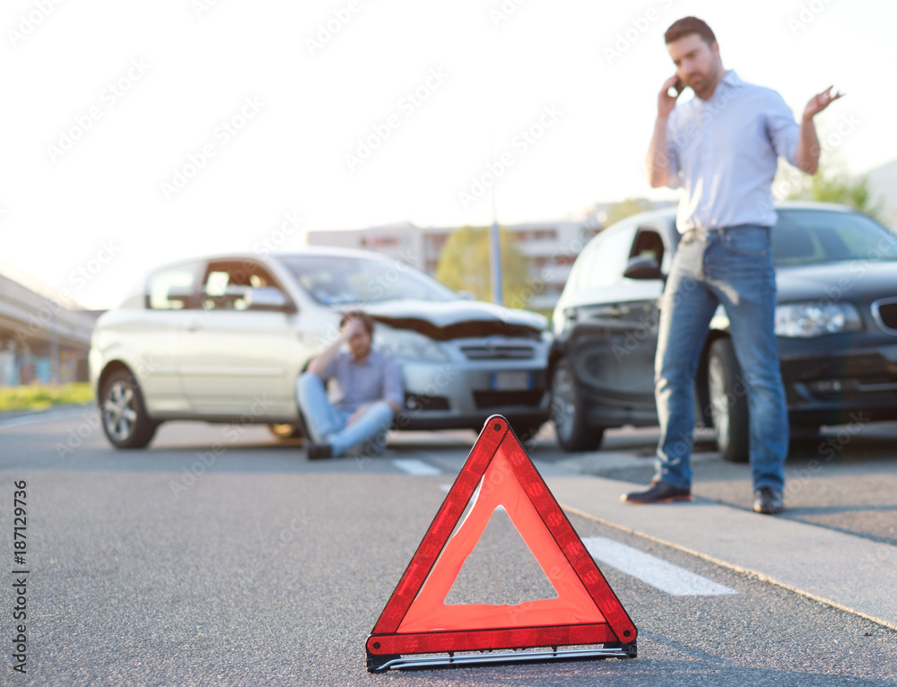 Men calling first aid after a bad car crash on the road - obrazy, fototapety, plakaty 