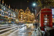 Traffic Jam In Street Of London At Night During Christmas Holidays With A Historical Phone Cab