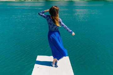 Happy casual tourist girl outside on tropical holiday destination.Travel and Vacation. Freedom Concept.Woman over blue water