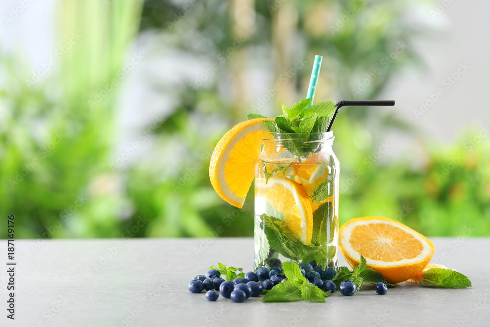 Mason jar of infused water with orange on table