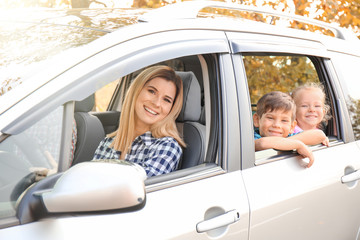 Wall Mural - Young woman with her little children in car