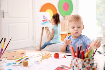 Poster - Little boy and blurred girl painting indoors