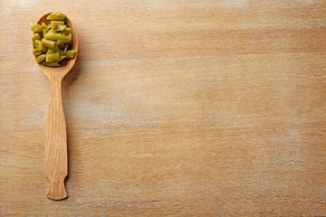 Canvas Print - Spoon with canned green beans on wooden background