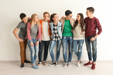group of cute teenagers near white wall