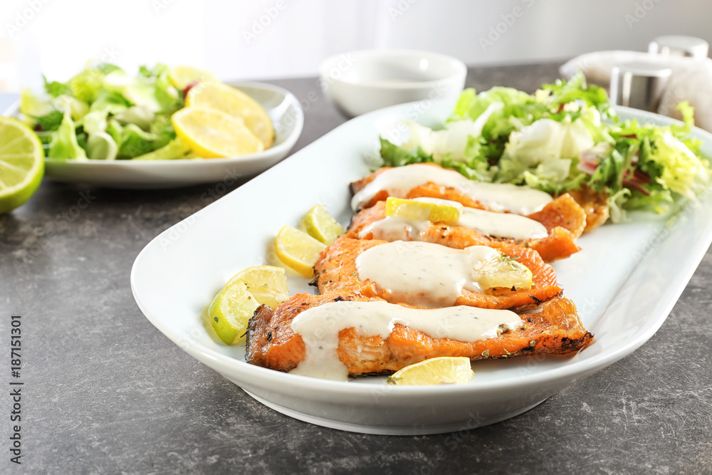 Tasty rainbow trout fillets with sauce on plate, closeup