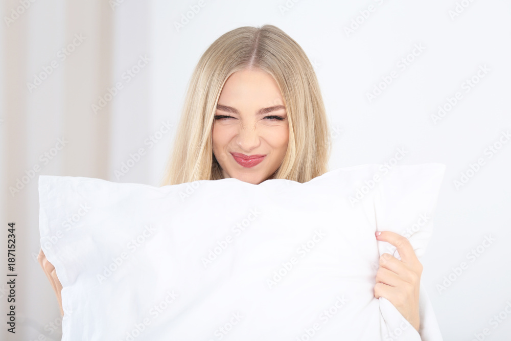 Young beautiful smiling woman with pillow at home