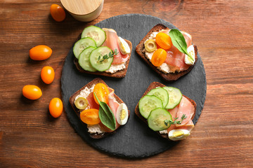 Canvas Print - Slate plate with tasty fresh bruschettas on table