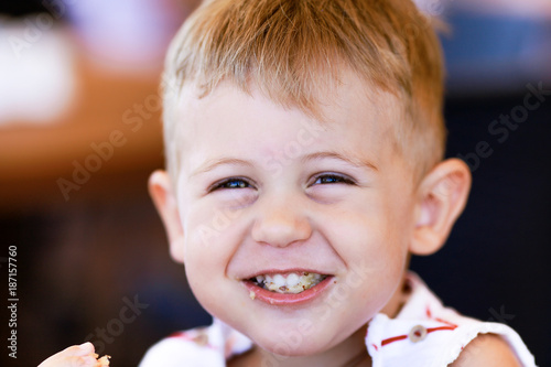 Portrait of blonde caucasian child eating a piece of bread Tableau sur Toile