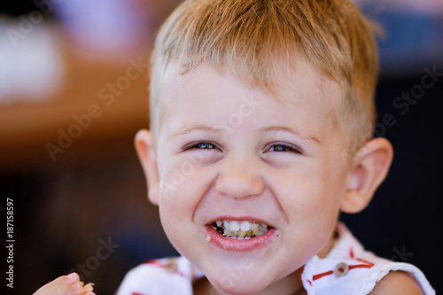 Portrait of blonde caucasian child eating a piece of bread Tableau sur Toile