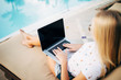 © F8  \ Suport Ukraine - happy young woman in shades with laptop computer over exotic beach with palm trees and pool background