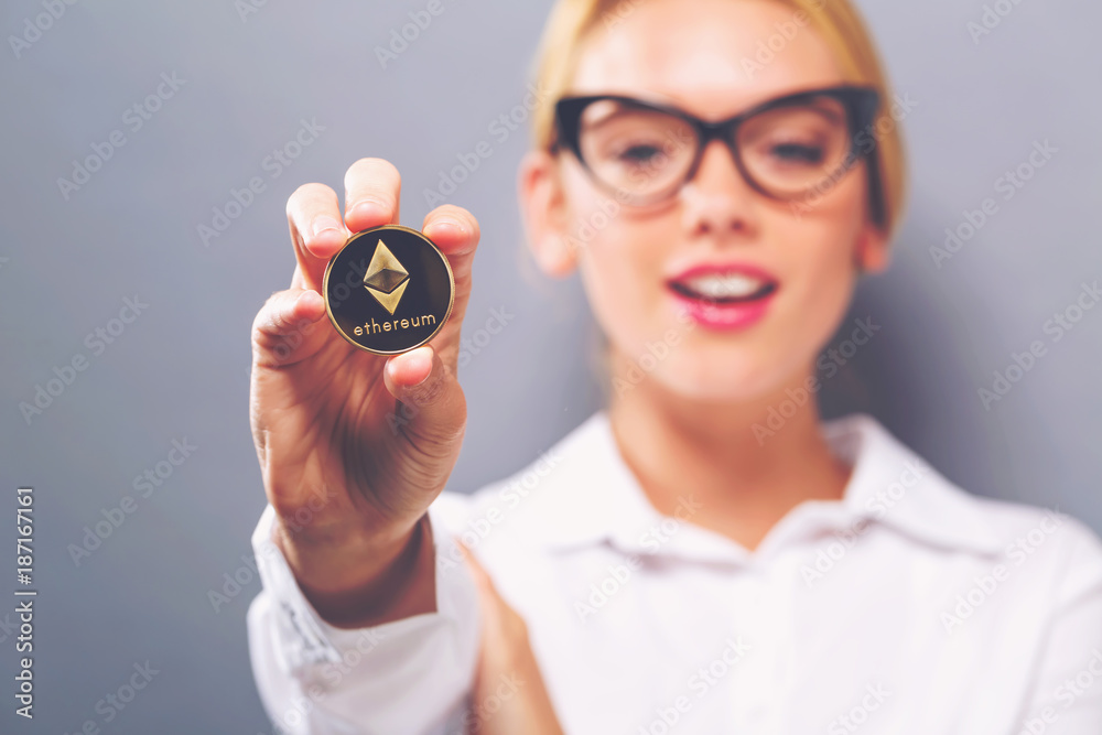 Woman holding a physical Ethereum coin cryptocurrency in her hand