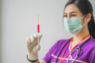 Female doctor with syringe. Nurse or health worker with syringe	