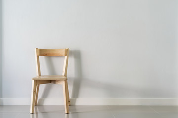 wooden chair against white wall in empty room