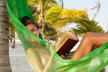 Wall Mural - Happy and beautiful woman lying in the hammock and reading book