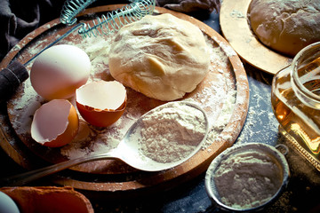 Wall Mural - Dough with flour on an old background in a composition with kitchen accessories