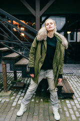 Wall Mural - Fashionable young girl model in trendy famous italian jeans and white old fashioned expensive sneakers posing for camera. European beautiful woman stylish look. Well dressed woman. Modern appearance.