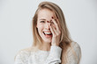 Leinwandbild Motiv Headshot of cute woman with dark eyes, blonde long hair, happy gentle smile rejoicing her success. Cheerful woman having birthday having pleased expression and pleasure. Face expressions