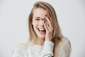 Wall Mural - Headshot of cute woman with dark eyes, blonde long hair, happy gentle smile rejoicing her success. Cheerful woman having birthday having pleased expression and pleasure. Face expressions
