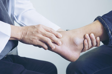 Doctor the traumatologist examines the leg examined at the medical office