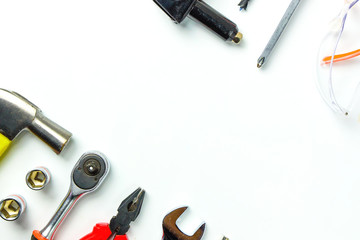 Top view of Working tools,wrench,socket wrench,hammer,screwdriver,plier,electric drill,tape measure,machinist square and safety glasses on white background.flat lay design for construction concept