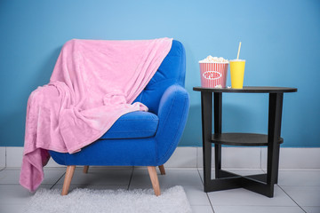 Poster - Comfortable armchair and table with snacks in home cinema. Watching movie