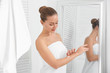 © Africa Studio - Young woman applying body cream in bathroom