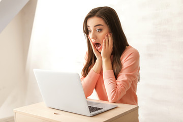 Poster - Emotional young woman with laptop at home